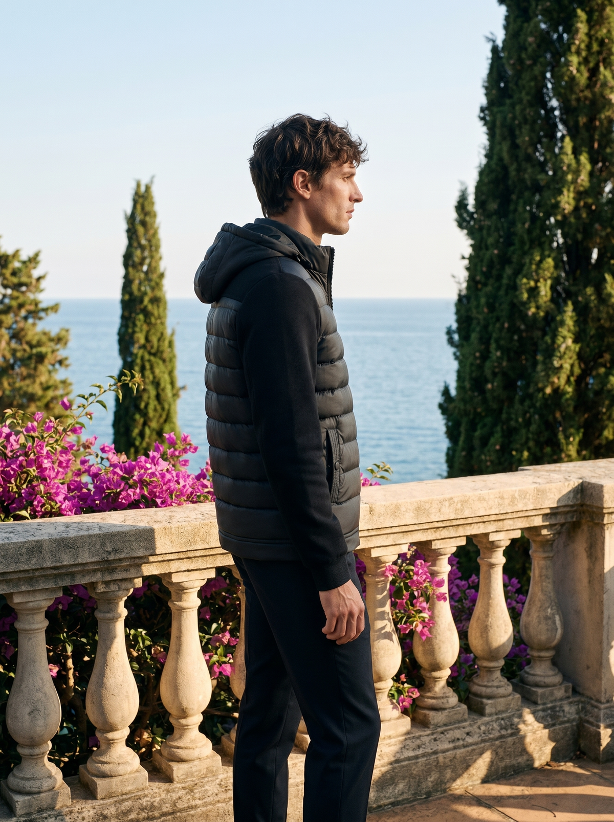 Side profile of a man wearing a hooded puffer jacket overlooking Lake Como — Belvoirne