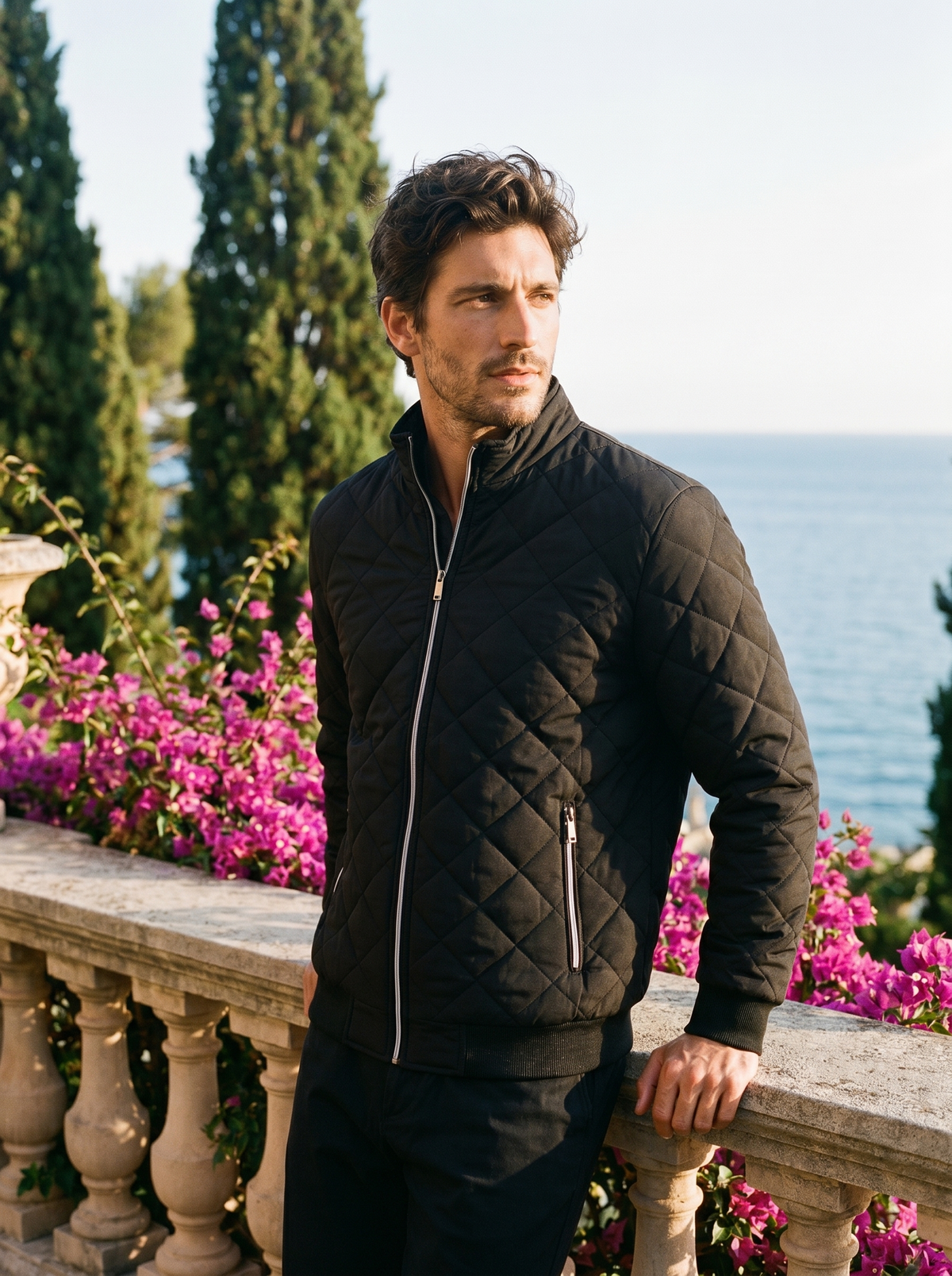 Man wearing a black fleece-lined quilted jacket on a balcony overlooking Lake Como, old money style — Belvoirne