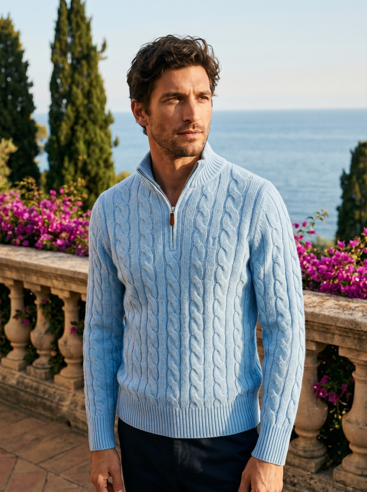 Man wearing a light blue cable knit wool half-zip jumper on a balcony overlooking Lake Como, old money style — Belvoirne