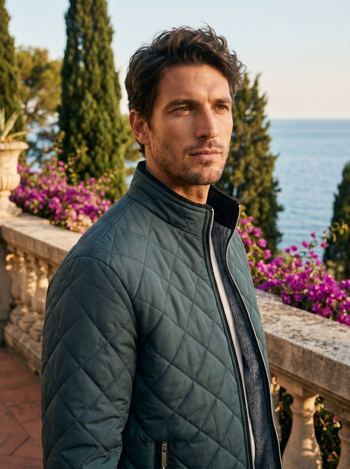 Man wearing a sage green fleece-lined quilted jacket on a balcony overlooking Lake Como, old money style — Belvoirne