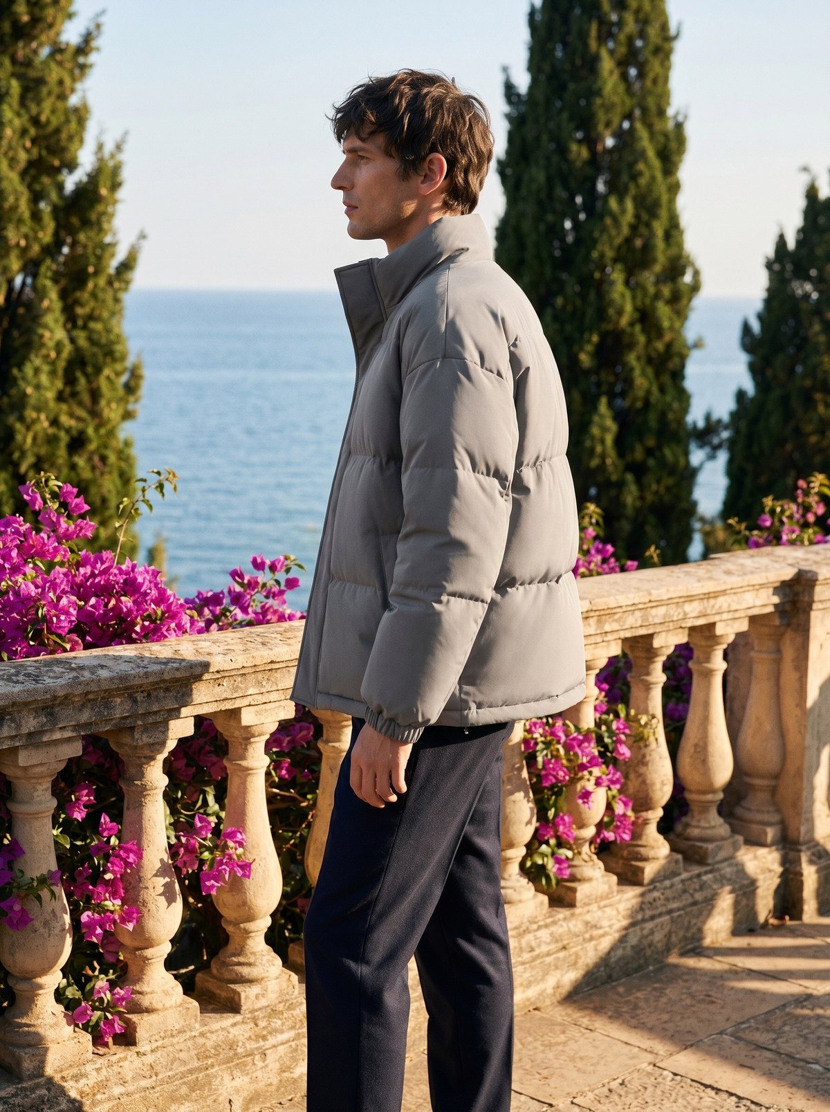 Side profile of a man wearing a puffer jacket overlooking Lake Como — Belvoirne