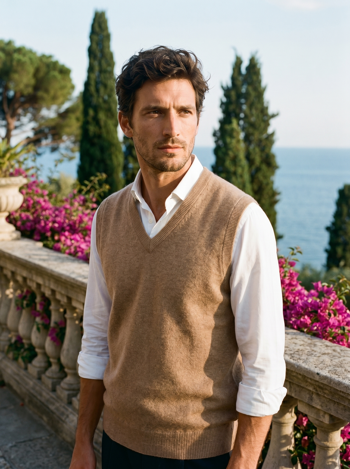 Man wearing a beige wool sweater vest over a shirt on a balcony overlooking Lake Como, old money style — Belvoirne