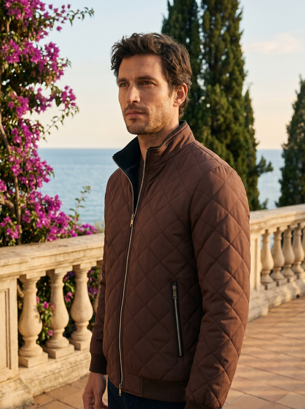Man wearing a cocoa brown fleece-lined quilted jacket on a balcony overlooking Lake Como, old money style — Belvoirne