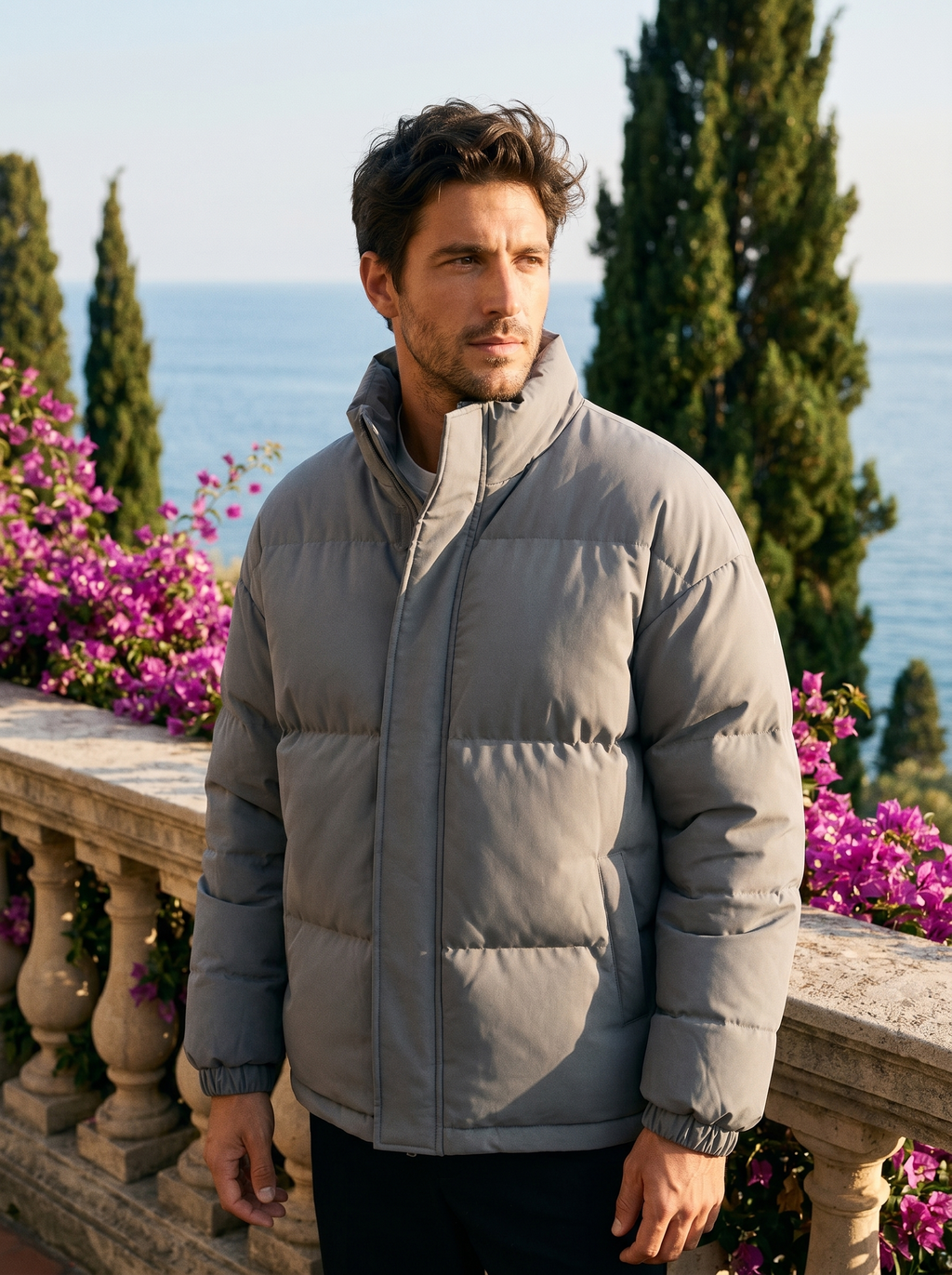 Man wearing a grey puffer jacket on a balcony overlooking Lake Como, old money style — Belvoirne