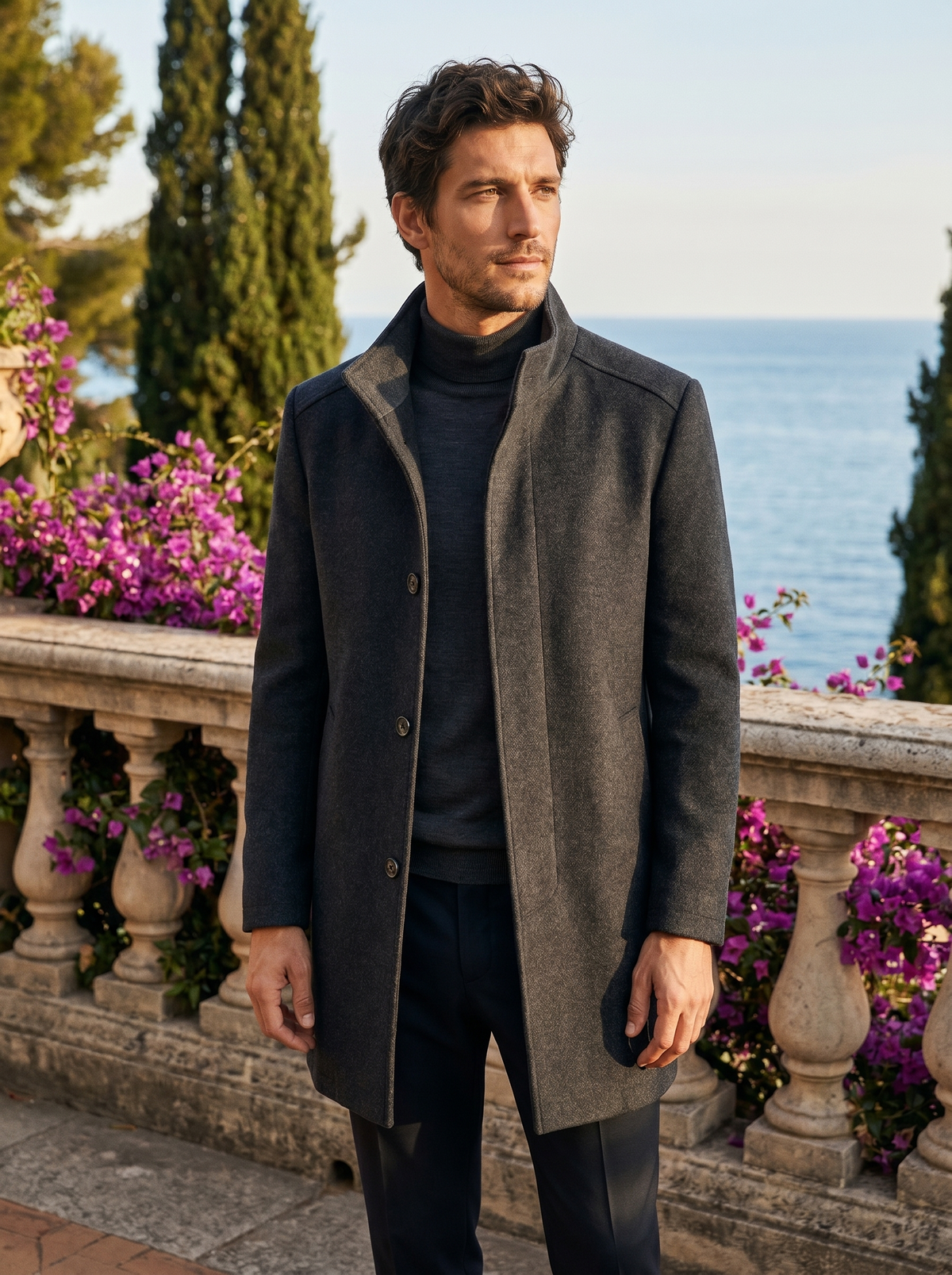 Man wearing a grey stand-collar tailored coat on a balcony overlooking Lake Como, old money style — Belvoirne