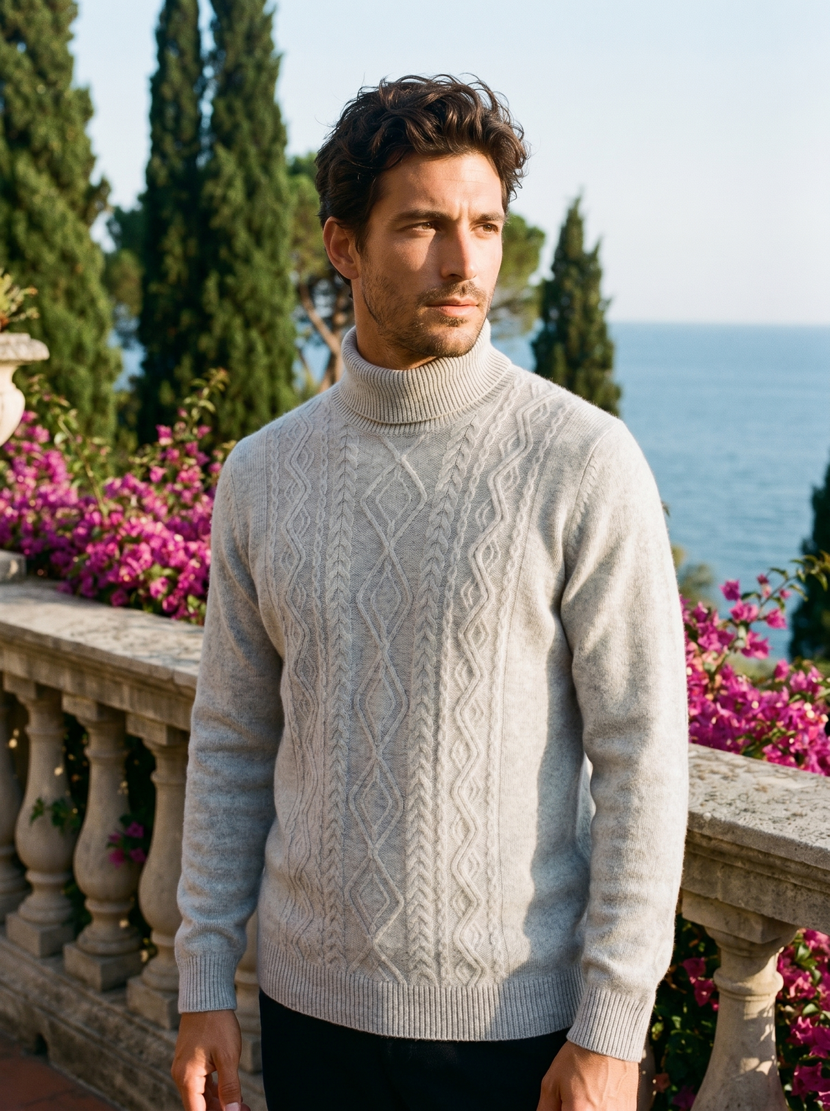 Man wearing a light grey cable knit wool roll neck jumper on a balcony overlooking Lake Como, old money style — Belvoirne