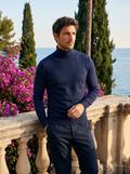 Man wearing a navy wool roll neck jumper on a balcony overlooking Lake Como, old money style — Belvoirne