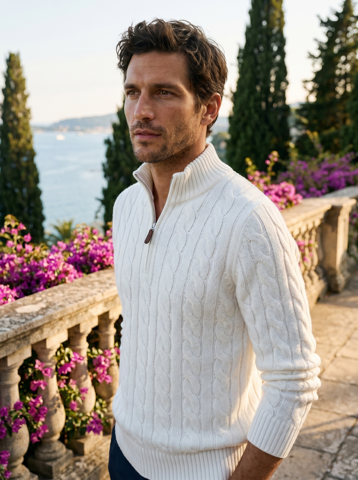 Man wearing a white cable knit wool half-zip jumper on a balcony overlooking Lake Como, old money style — Belvoirne