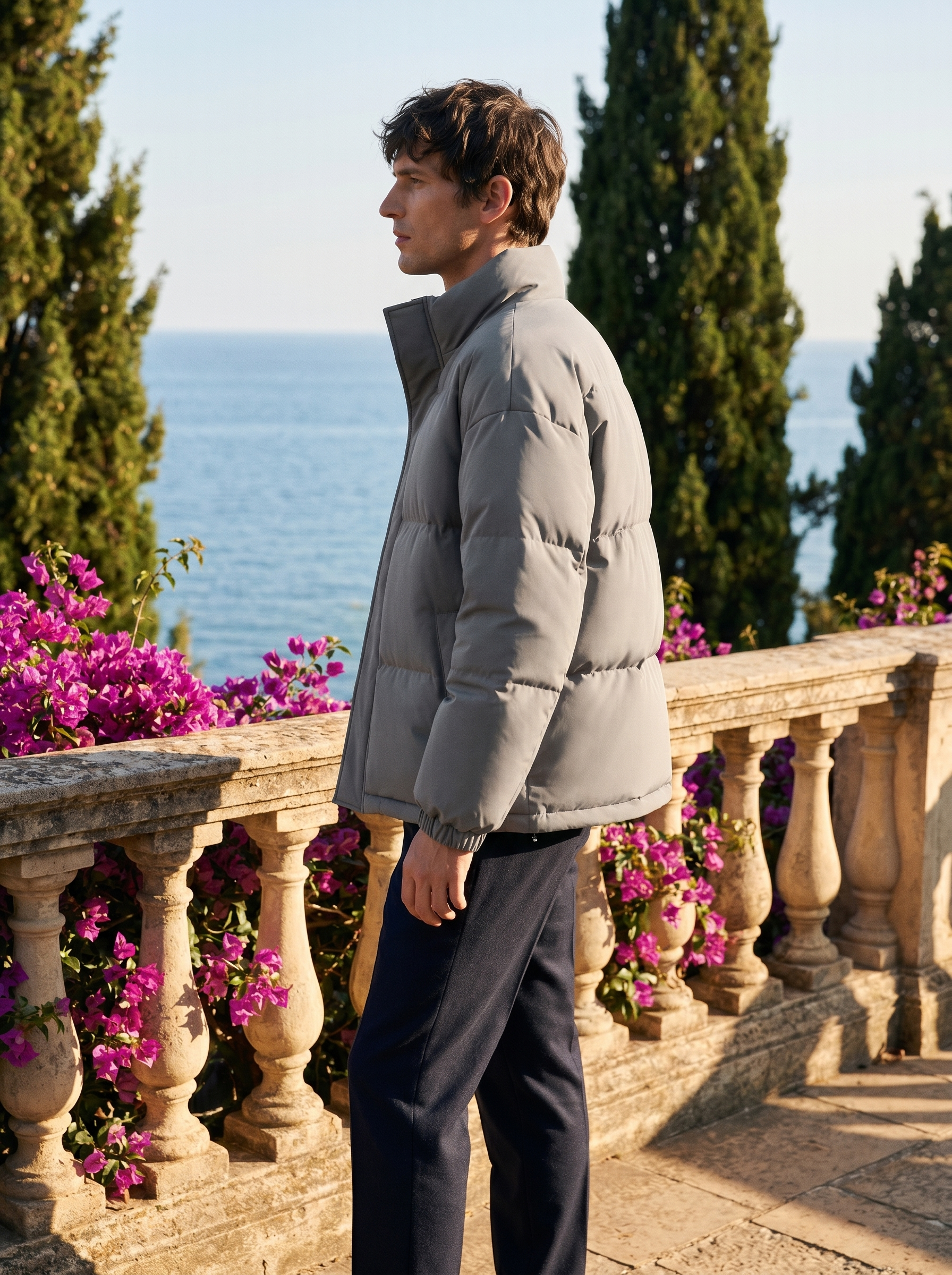 Side profile of a man wearing a puffer jacket overlooking Lake Como — Belvoirne